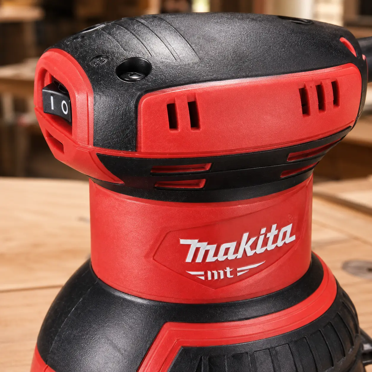 Makita M9204: lijadora excéntrica Ø125 mm con velocidad fija, bolsa de polvo y conexión a aspirador.